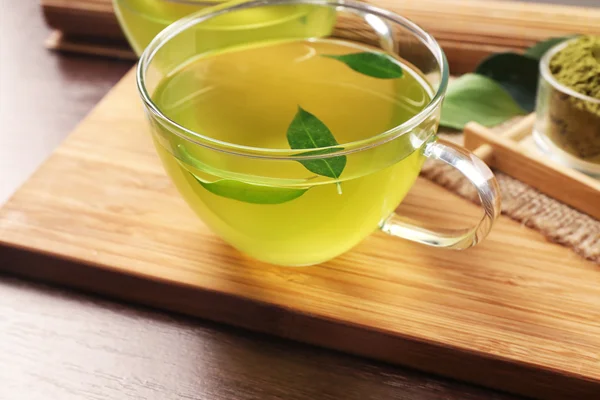 Tazas de té verde matcha en primer plano de tabla de cortar de madera —  Fotos de Stock