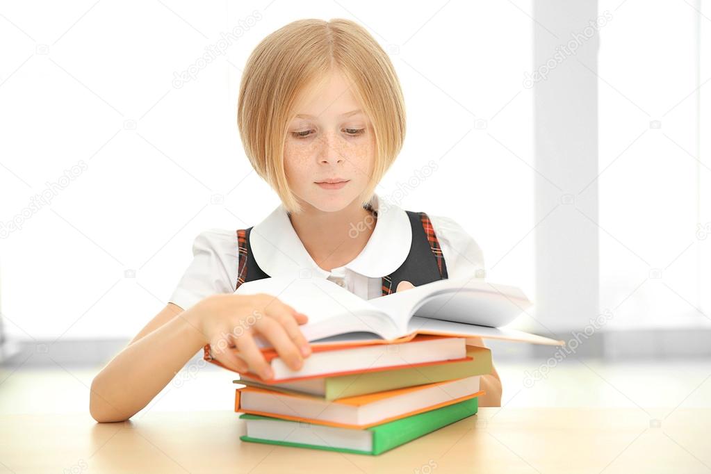 Smiling girl with many books 