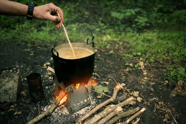 Man cooking on fire in forest