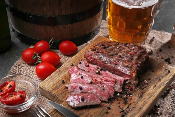 Lekkere gegrilde biefstuk met bier op snijplank — Stockfoto