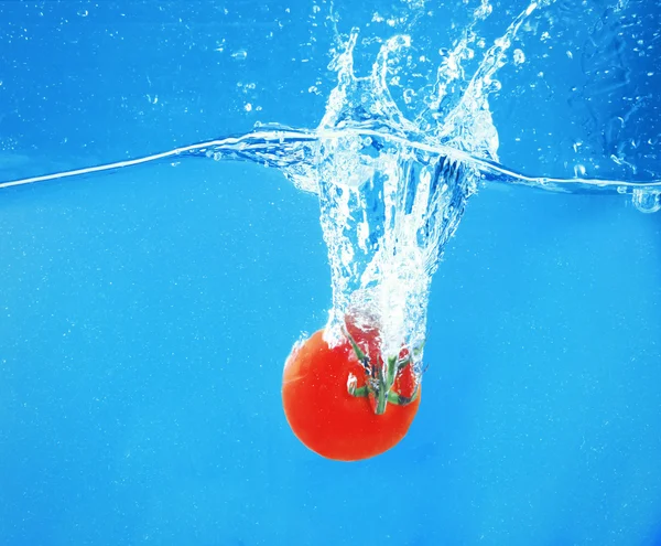 Frische Tomaten fallen ins Wasser — Stockfoto
