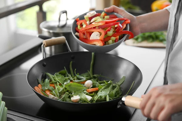 Mains masculines mettant légumes — Photo