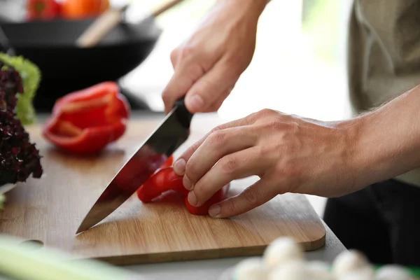 Mãos masculinas corte pimenta vermelha — Fotografia de Stock