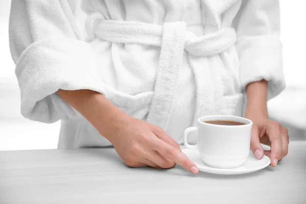 Woman holding cup of coffee in kitchen — Stock Photo, Image