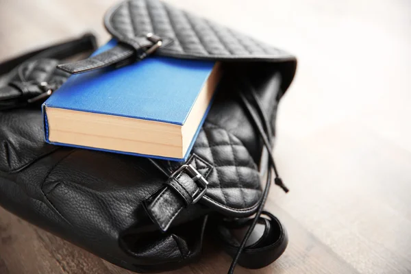 Leather backpack and book — Stock Photo, Image