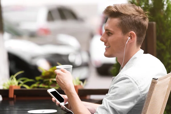 Hombre escuchando música en la cafetería —  Fotos de Stock