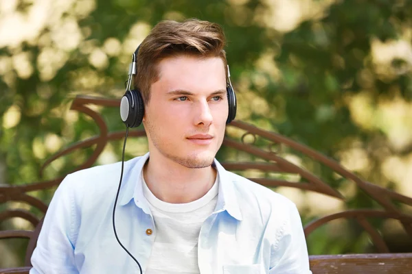 Man listening music in park — Stock Photo, Image