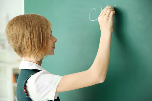 女学生在黑板上书写 — 图库照片