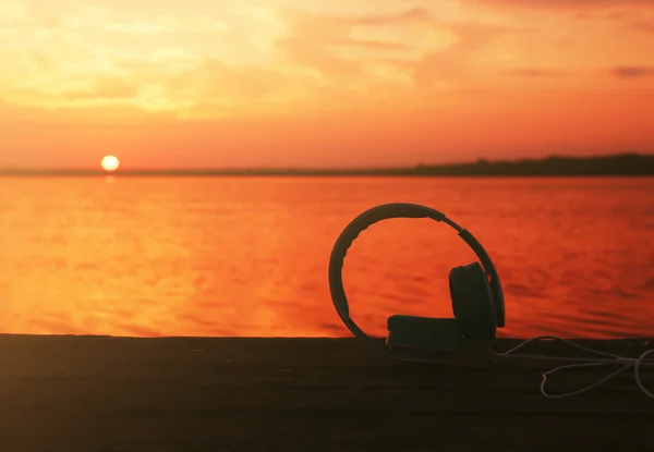 Headphones on sunset sky — Stock Photo, Image
