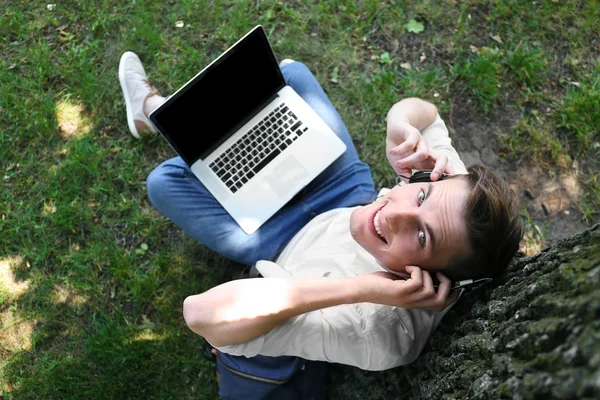 Man with laptop listening music outdoor — Stock Photo, Image