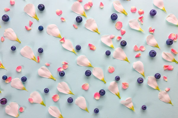 Blueberries and flower petals — Stock Photo, Image