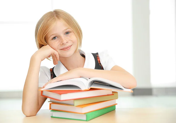 Menina sorridente com muitos livros — Fotografia de Stock