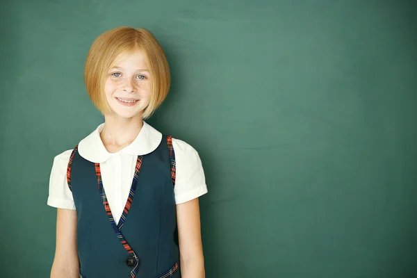 Schoolgirl on chalkboard background — Stock Photo, Image