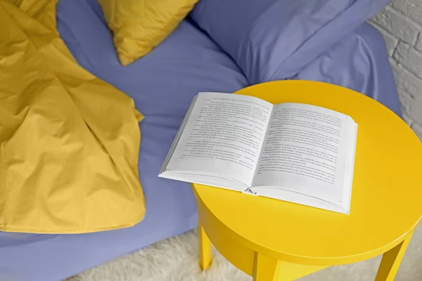 Livre ouvert sur table de chevet jaune — Photo