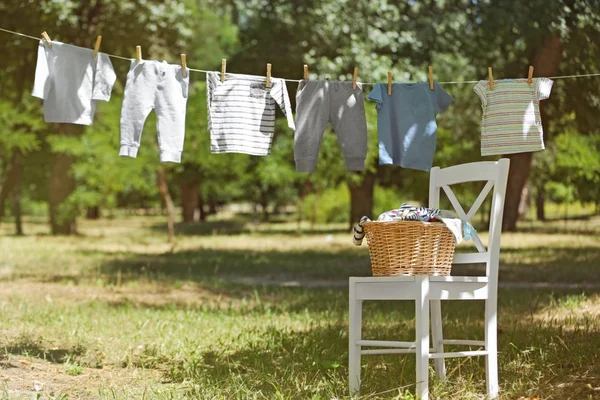 Wicker basket on white chair and baby laundry Royalty Free Stock Images