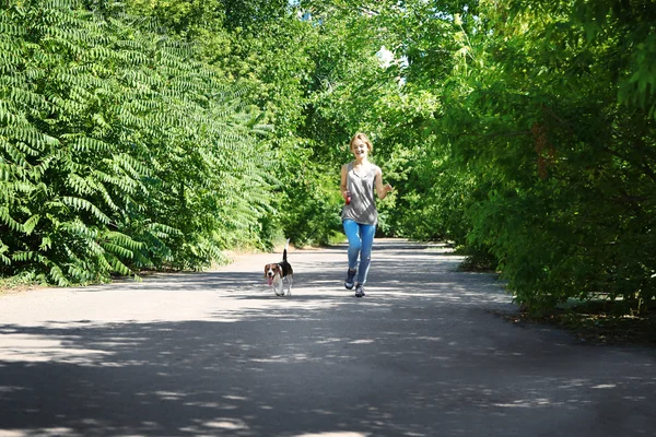 Jovem mulher caminhando com cão — Fotografia de Stock