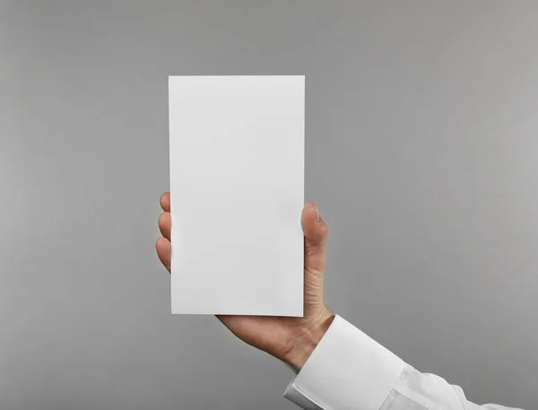 Man's hand holding white paper — Stock Photo, Image