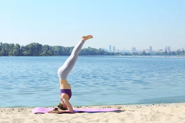 Jonge vrouw doet yoga door de rivier — Stockfoto