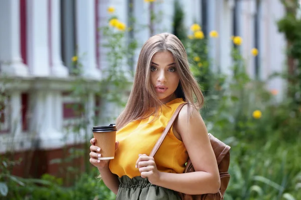 Kvinna med kopp kaffe på gatan — Stockfoto