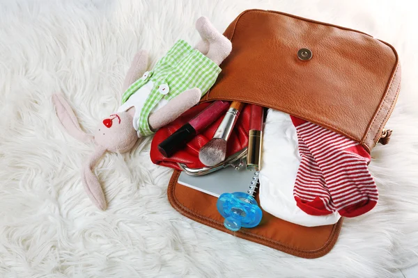 Bolso de madre con accesorios en la alfombra — Foto de Stock