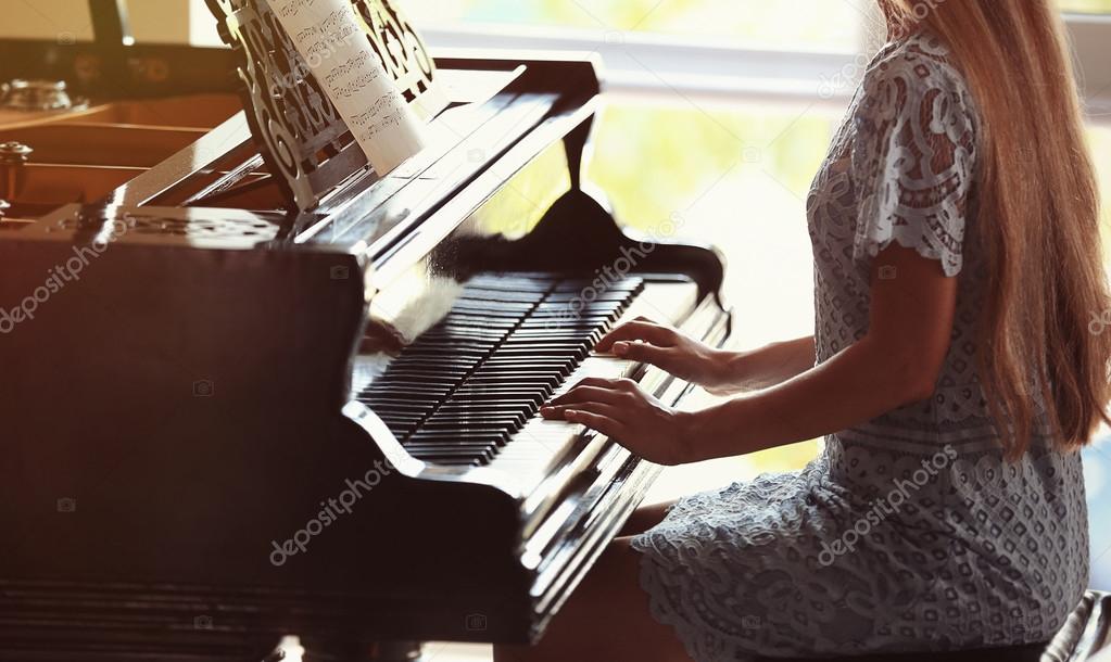 Woman playing piano Stock Photo by ©belchonock 121705144