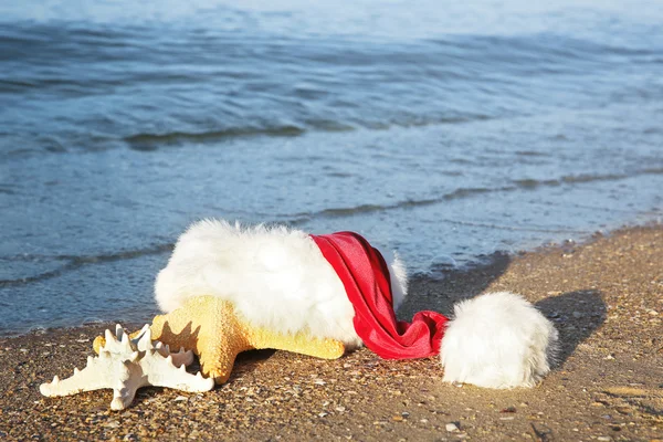 Santa hat z gwiazdy morza na plaży. — Zdjęcie stockowe