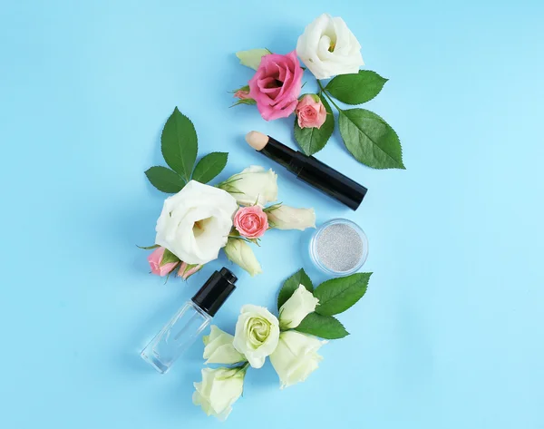 Cosméticos e flores em azul — Fotografia de Stock