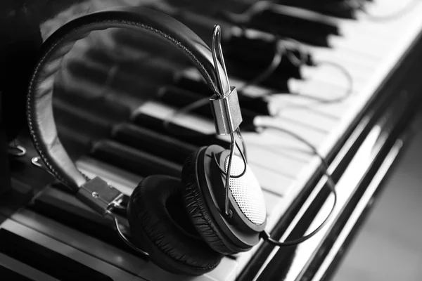 Modern headphones on piano keys — Stock Photo, Image