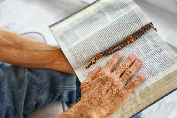 Starý muž drží a čtení Bible — Stock fotografie