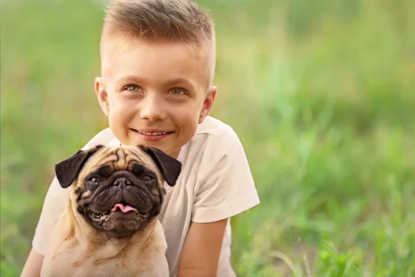 Schattige jongen met pug hond — Stockfoto