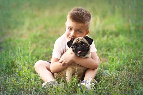 Schattige jongen met pug hond — Stockfoto