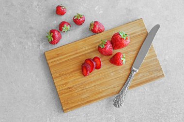 kesme tahtası üzerinde çilek dilimlenmiş