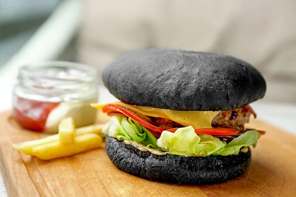 Leckerer schwarzer Burger mit Pommes — Stockfoto