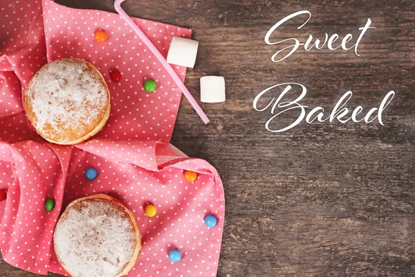 Köstliche zuckerhaltige Donuts mit rosa Serviette — Stockfoto