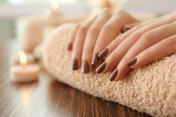 Vrouwelijke bruin manicure op handdoek — Stockfoto