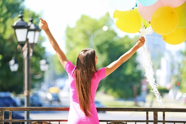 Girl with balloons on street — Stock Photo, Image