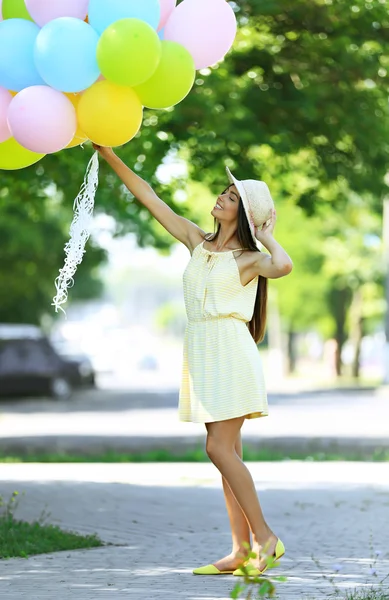 Girl with balloons on street — Stock Photo, Image