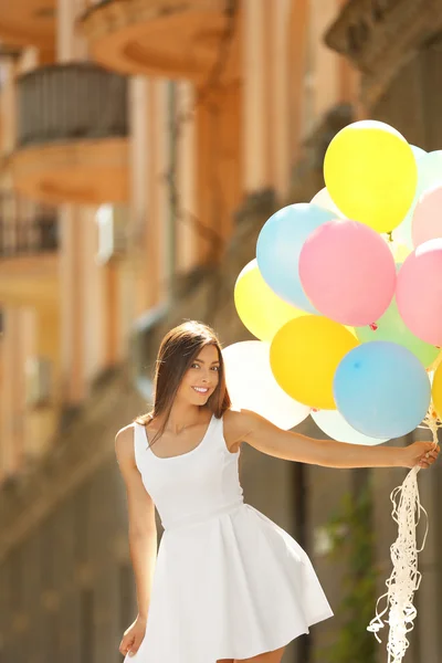 Girl with balloons on street — Stock Photo, Image