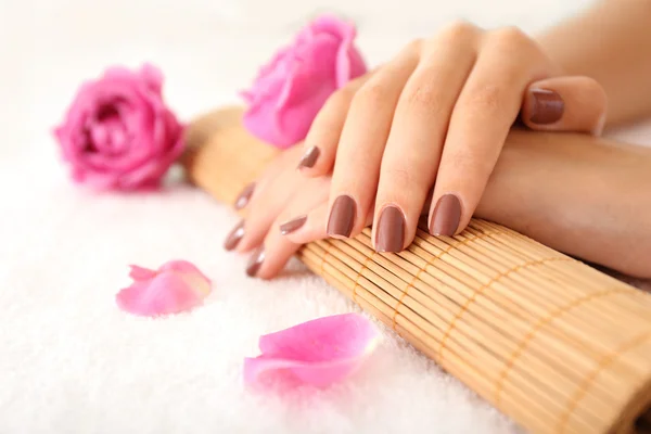 Mãos femininas com manicure marrom — Fotografia de Stock