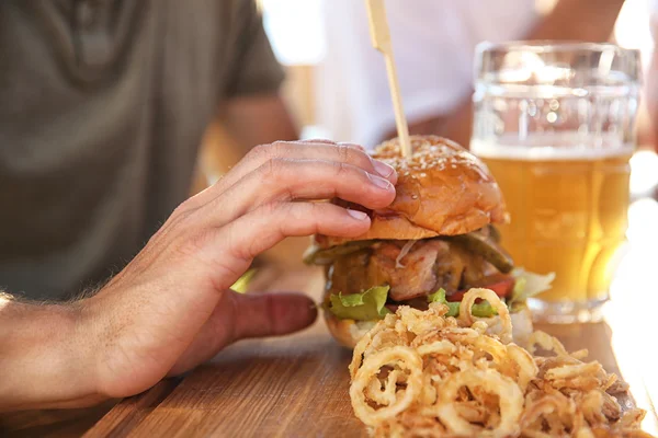 Hombre bebiendo cerveza y comiendo bocadillos — Foto de Stock