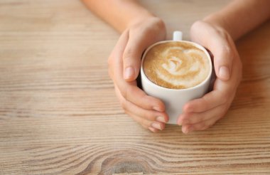 Ellerin kahve bardağını tutuyor.