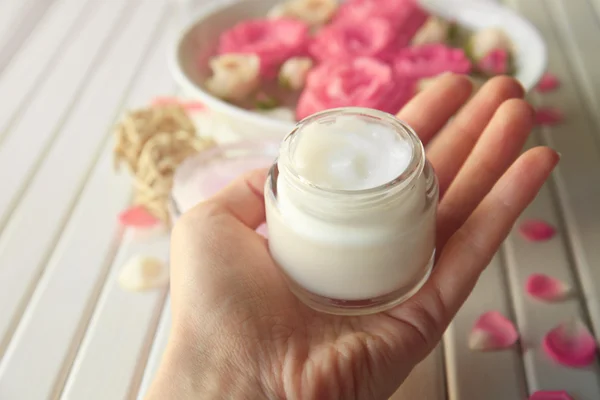 Female hand holding cosmetic cream — Stock Photo, Image