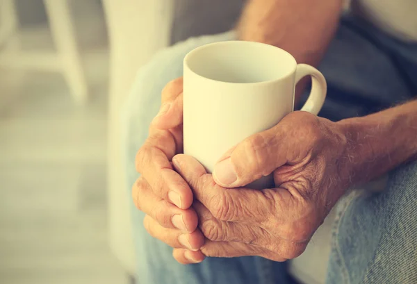 Old man holding cup — Stock Photo, Image