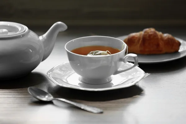 Чашка чая с круассаном — стоковое фото
