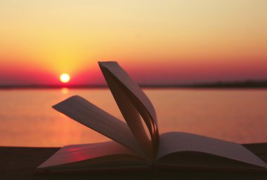 Günbatımı üzerinde açık kitap 