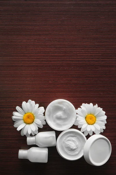 Crème cosmétique et boutons de fleurs — Photo