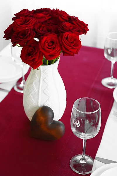 Ваза з червоними трояндами на столі — стокове фото