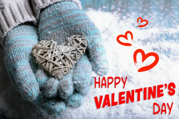 Female hands in mittens holding heart — Stock Photo, Image