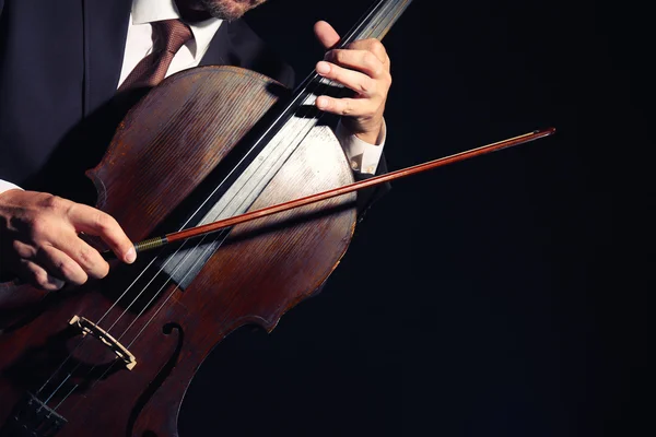 Uomo che suona il violoncello nell'oscurità — Foto Stock
