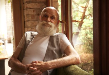 Cam kenarında oturan yaşlı adam